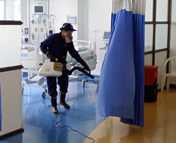 Técnico de Sergecol saneamiento ambiental realizando desinfección en área hospitalaria con equipo de aspersión